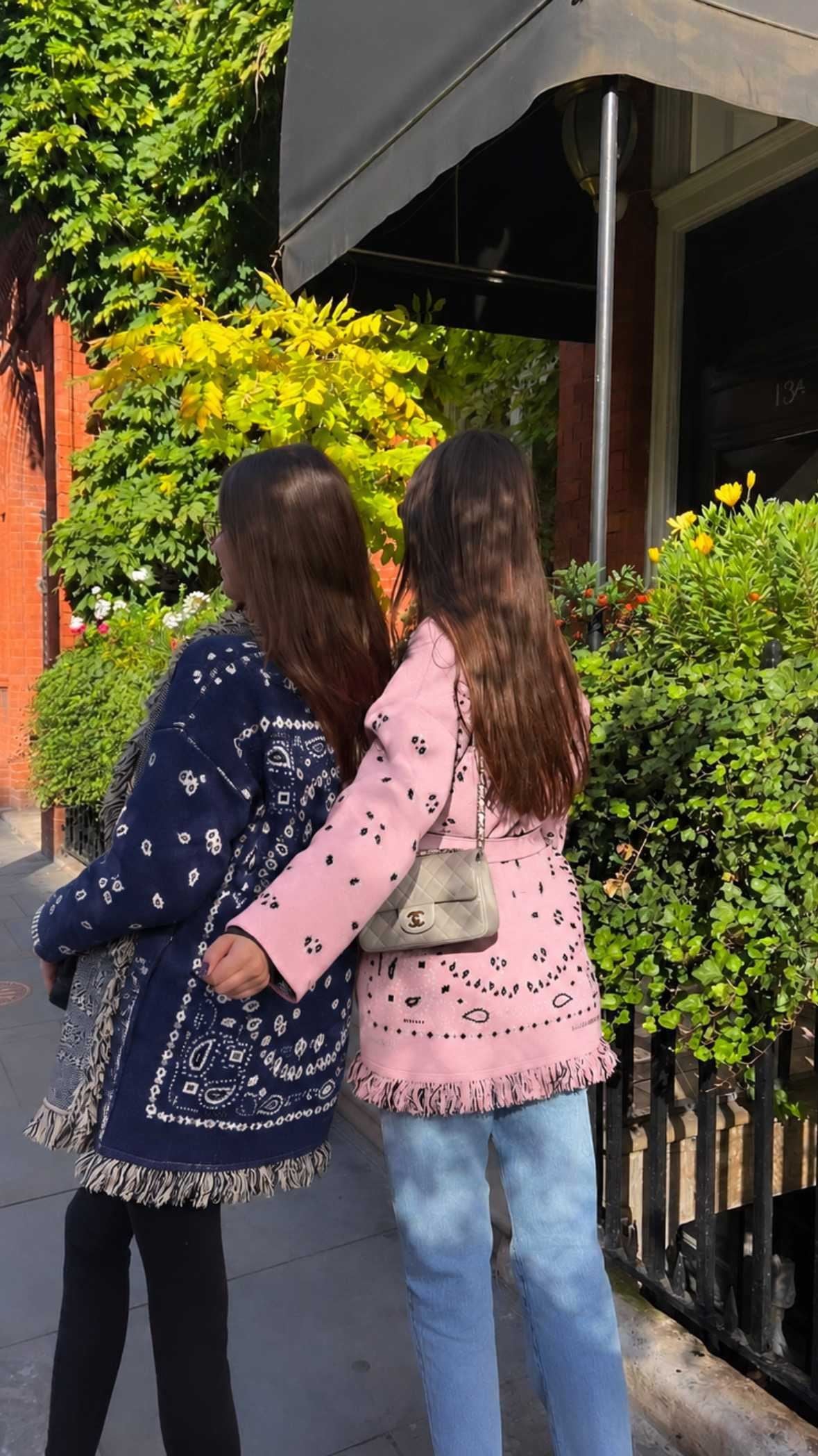 Two women seen from behind in the navy and pink bandana cardigans